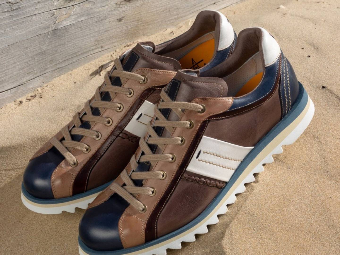 Sneakers uomo 2025 in pelle artigianale, modelli Musto Calzature su sfondo sabbia